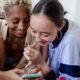 Two woman looking at a phone screen, happy, engaging in digital self care